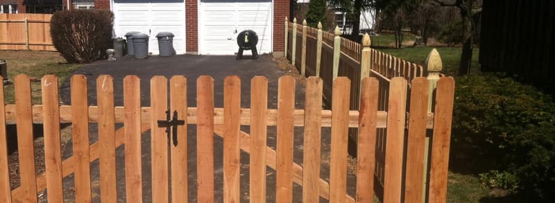 Wood picket gate and fence at a driveway
