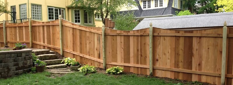 Wood privacy fence with steps and landscaping beside house
